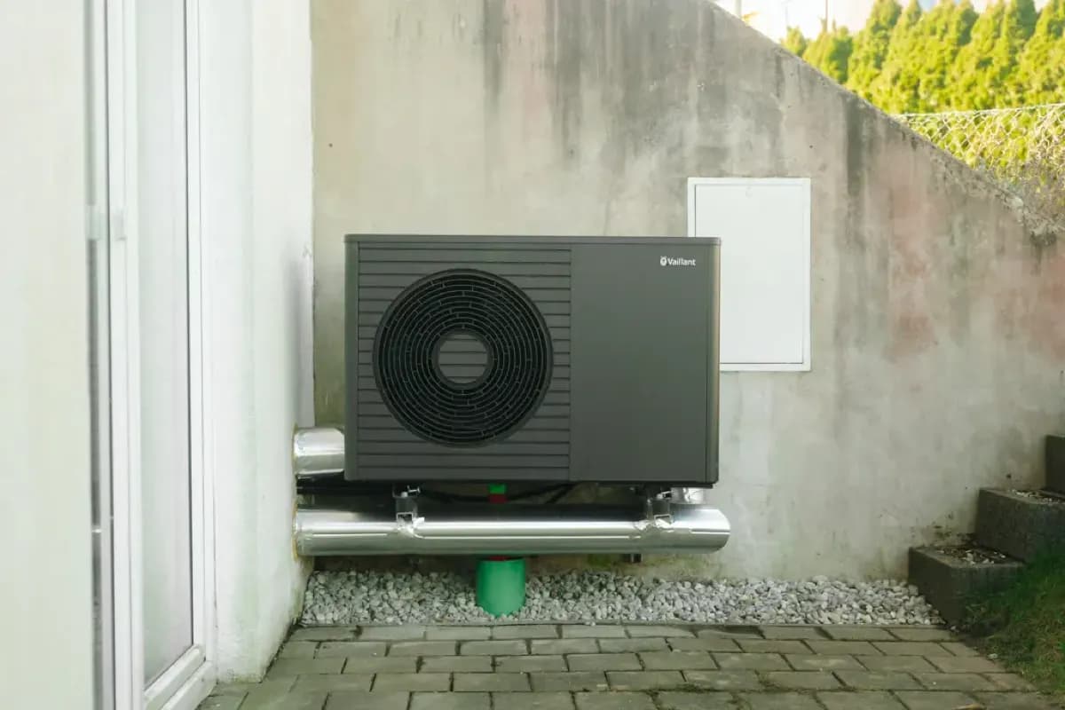 Außeneinheit einer Wärmepumpe an der Hauswand mit Leitungsführung